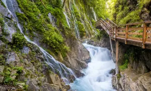 Holzwanderweg führt an rauschenden Wasserfällen vorbei durch die Berchtesgadener Alpen.