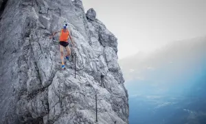 Anton Palzer bezwingt den Watzmann, ein Trailrunner in Aktion auf steilem Fels mit Sicherungsseil.