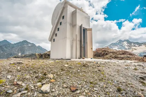 Moderne Kapelle am Pitztaler Gletscher, umgeben von felsiger Landschaft und schneebedeckten Bergen.