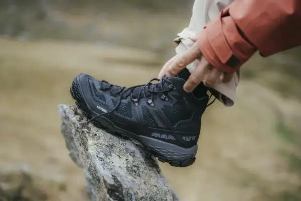 Schwarzer, robuster Wanderschuh von Mammut mit Gore-Tex, der auf einem Felsen ruht. Perfekt für jedes Abenteuer, welche Wanderschuhe sind das wohl?