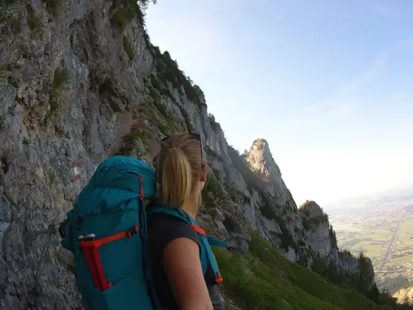 Wanderin auf dem Salzburger Hochthron, mit Blick auf steile Felsen und das Tal.